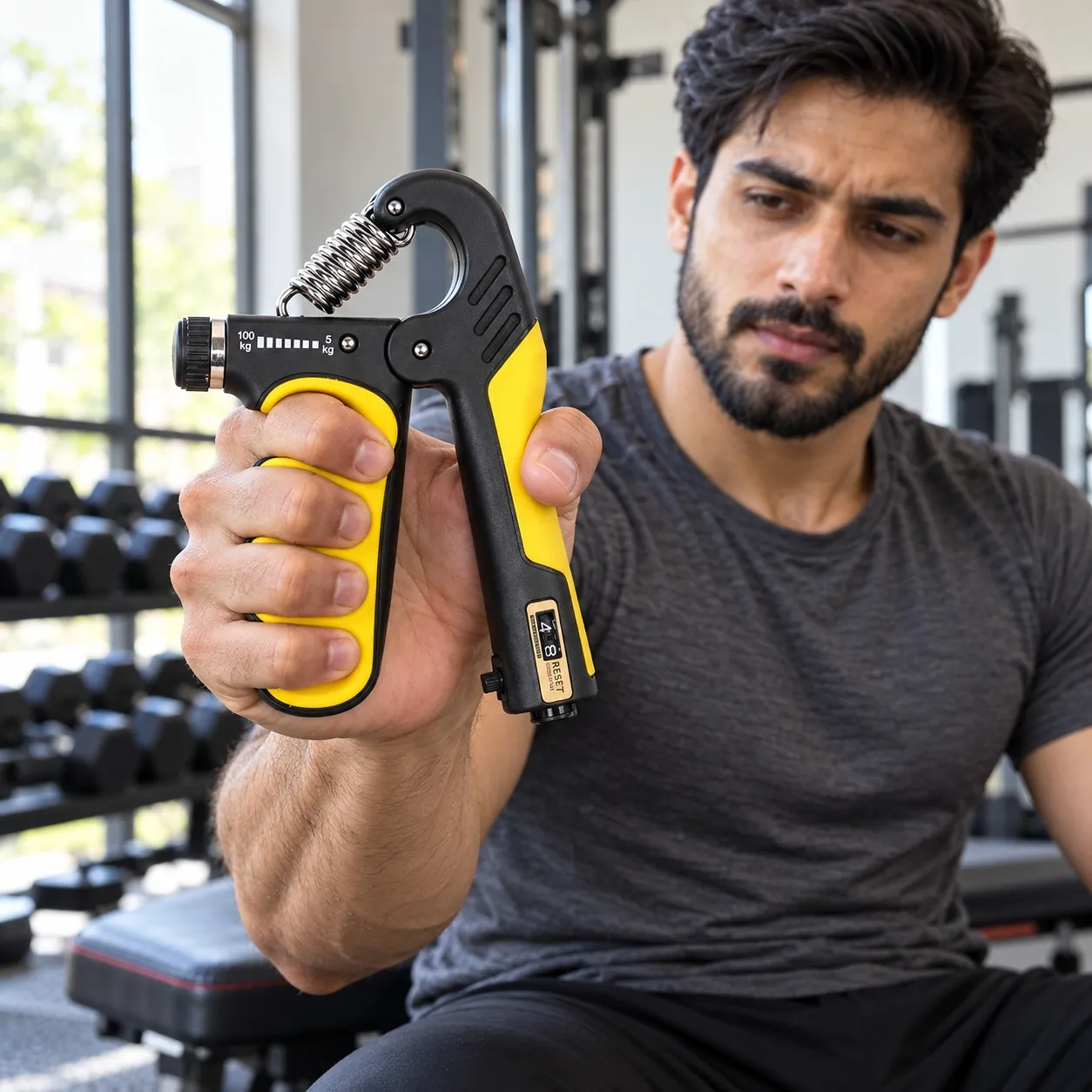 Man training with the yellow hand gripper with counter
