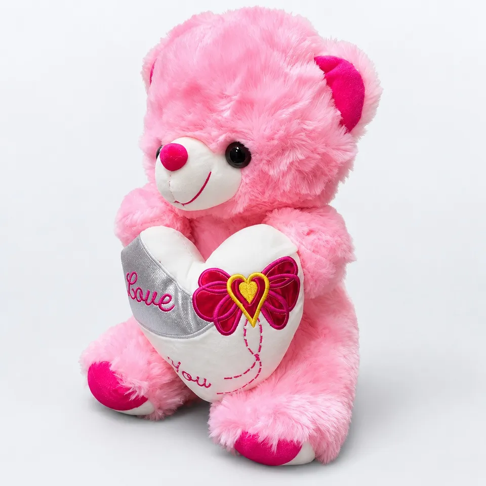 Fluffy pink teddy bear with a heart, side view