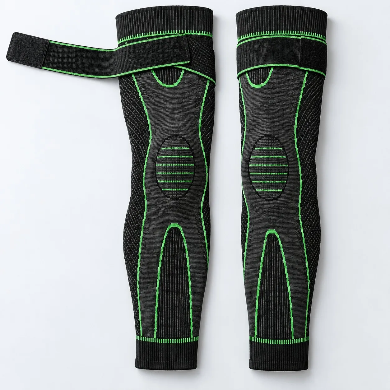 Two DMERET full leg knee sleeves laid flat, one strap open