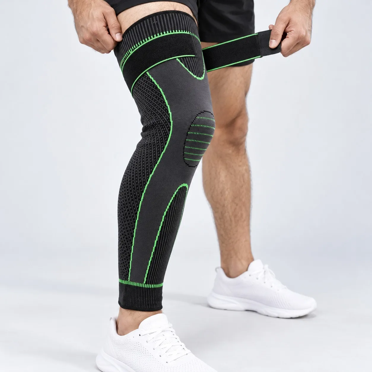 Man fastening the thigh strap of a full leg knee support sleeve